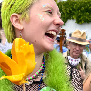 yellow-green colored hair woman smiling eating mango